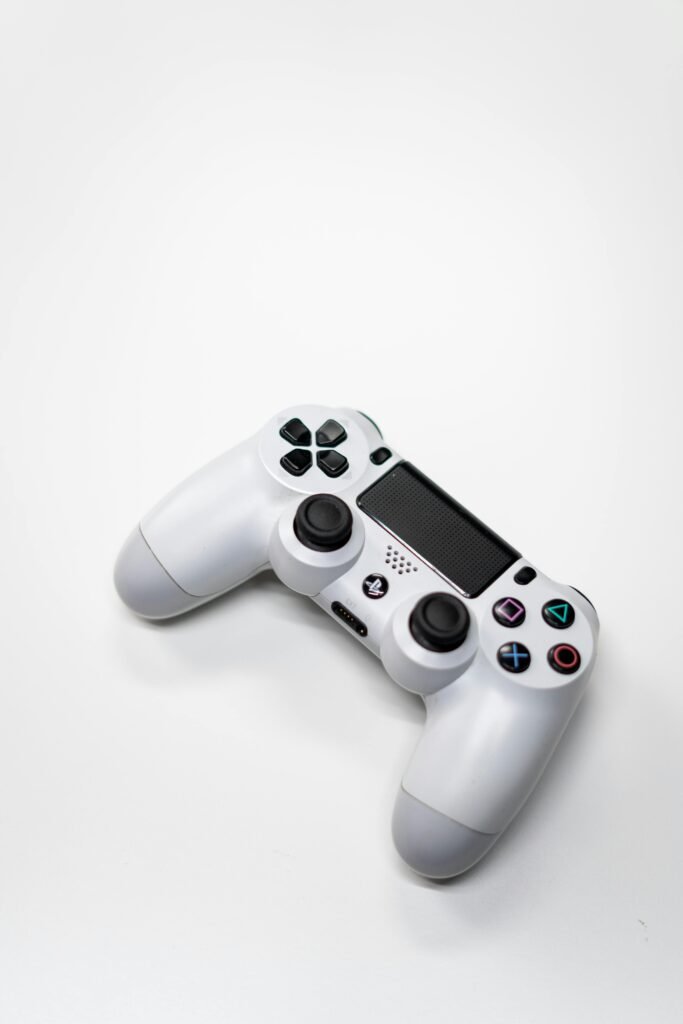 Minimalist image of a white gaming console controller isolated on a bright white background.